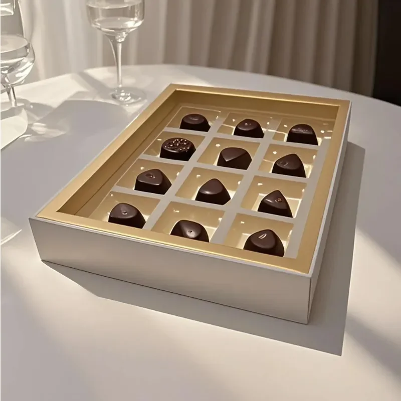 Open chocolate gift box with gold tray and individual pralines