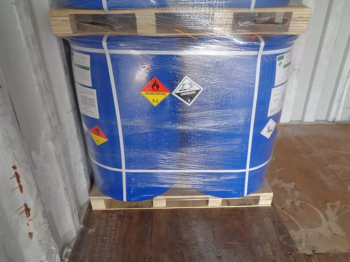 IBC tote of liquid chemical strapped to a pallet inside a shipping container