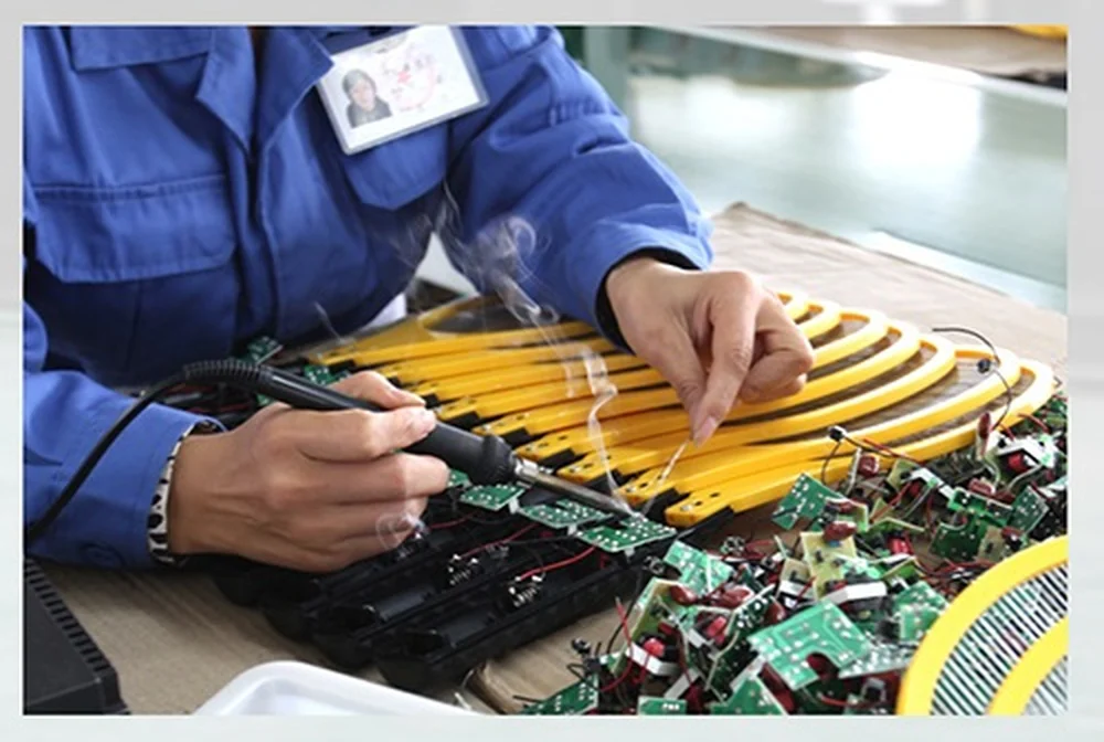 DANQ technician inspecting the high voltage circuit board of a mosquito swatter