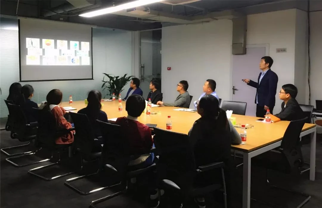 Business team meeting in a conference room with a presenter standing beside a projection screen