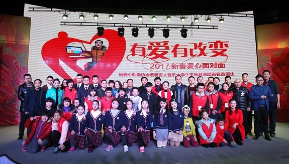 Group of people posing for a photo on a stage in front of a large screen with Chinese text.