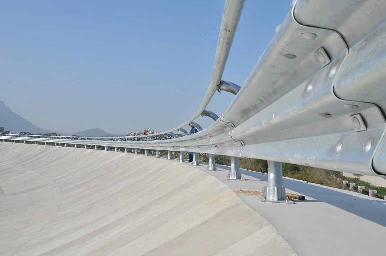 Galvanized guardrail running along a banked proving ground curve under a clear sky