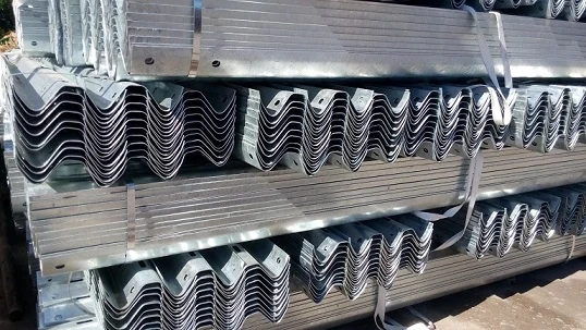 Galvanized flex beam guardrail sections stacked in the Hongda finished product area