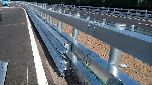 Galvanized steel highway guardrail with W-beam and posts installed along a road