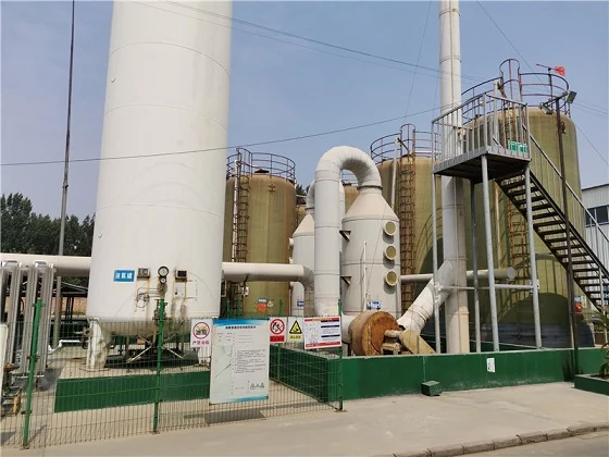 Industrial scrubber system with tanks, pipes, and stairs behind a fence