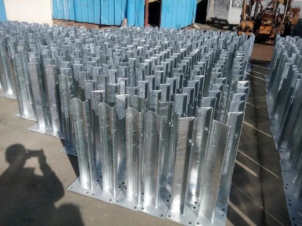 Bolt-down guardrail post with steel plate and long bolts securing to concrete