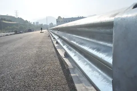 W-beam guardrail installed along a highway shoulder on galvanized posts