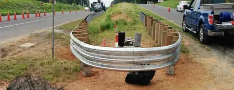 Close-up of curved W-beam guardrail section with precise radius and galvanized finish
