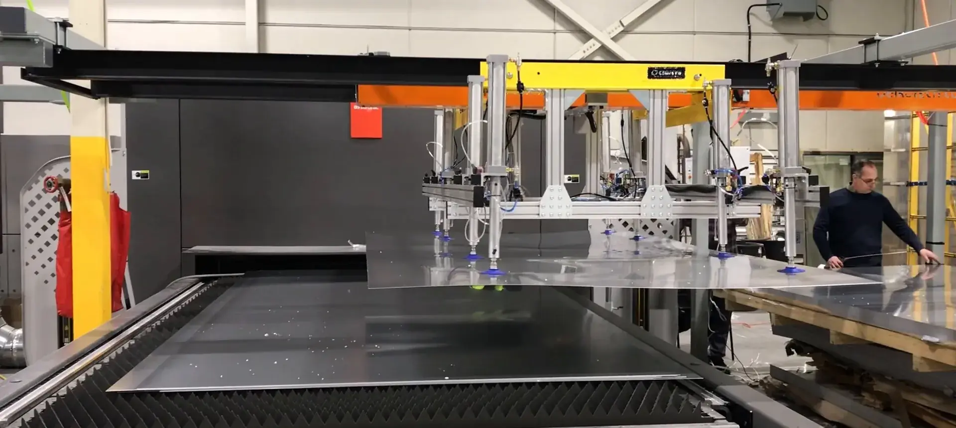 Gantry pick and place head positioned over the laser cutting bed in the Delkotech build shop