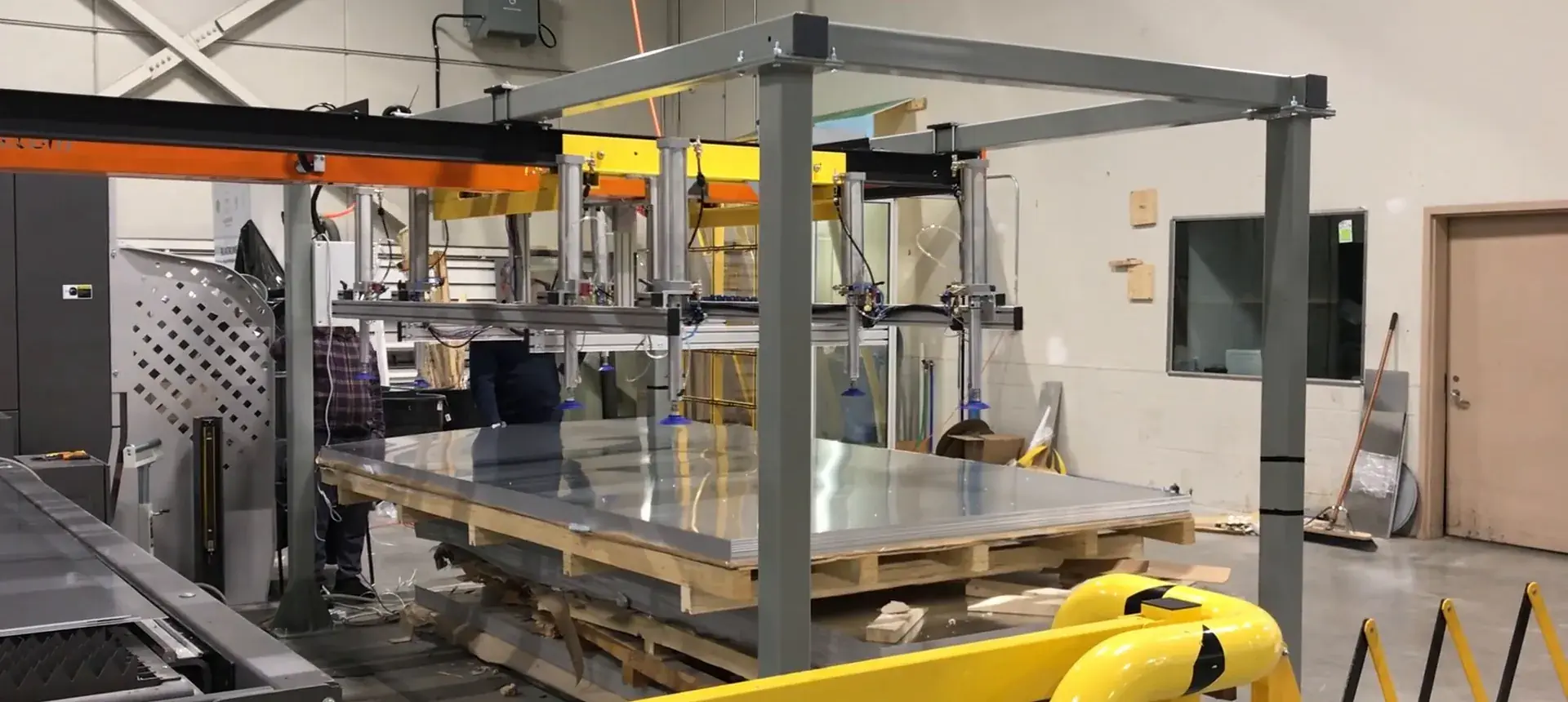 Delkotech gantry de-stacker lifting an aluminium blank from a pallet at the loading station