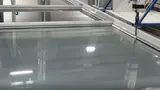 Large glazed panel on the bed of a CNC silicon window machine