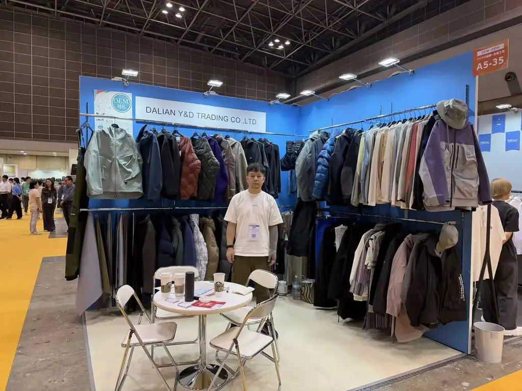 Dalian Y&D Trading Co Ltd exhibition booth hung with outdoor jackets and shells at an apparel OEM trade fair