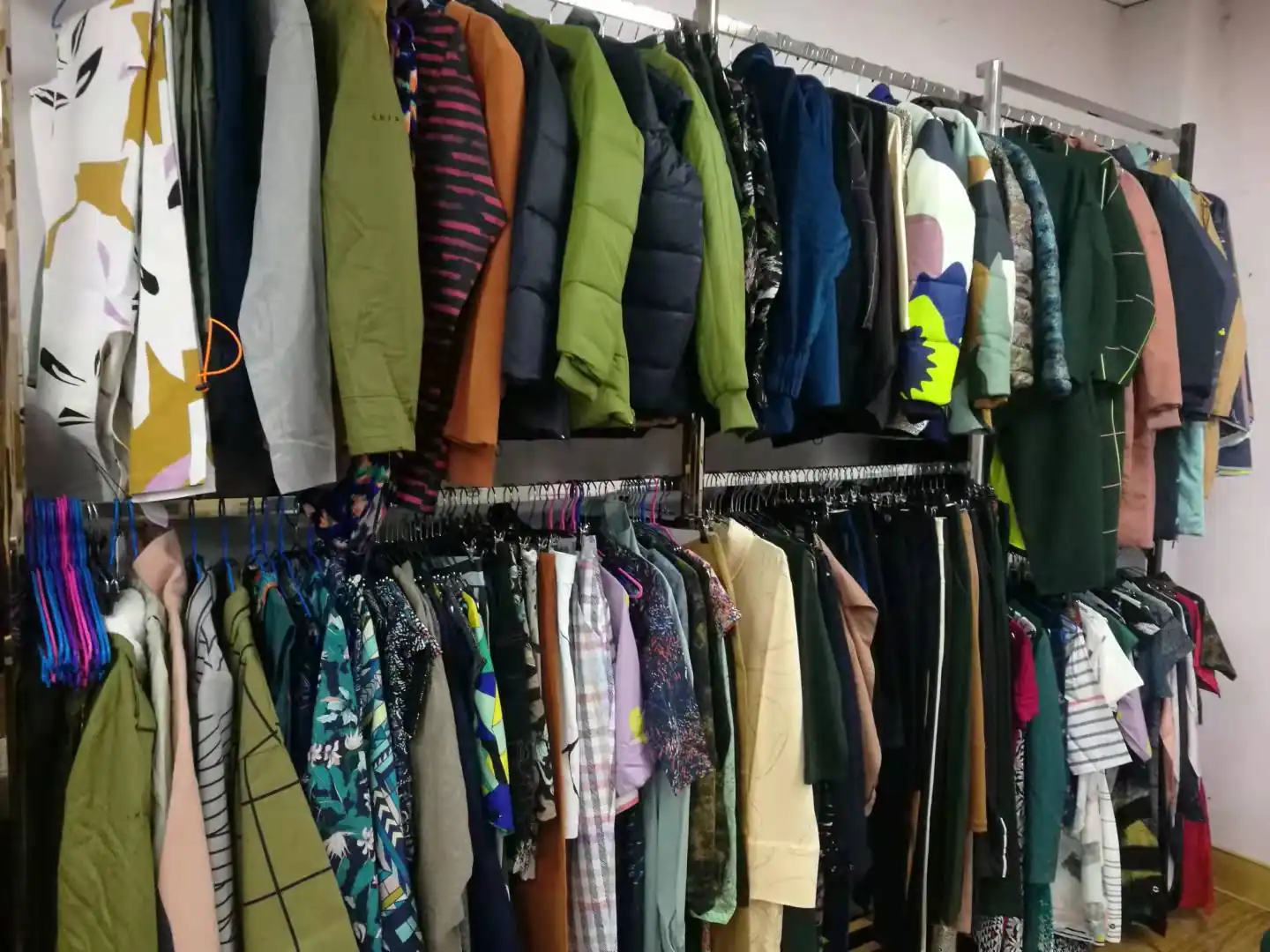 Rails of sample garments in the Y&D showroom including padded jackets, fleeces and printed woven pieces