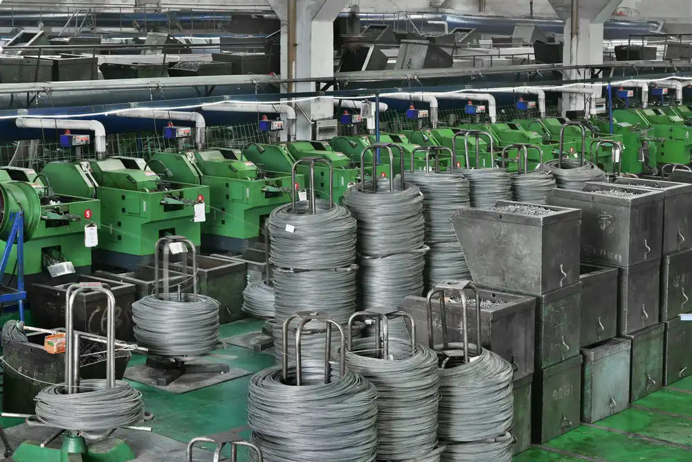 Operator setting up a cold heading machine on the shop floor
