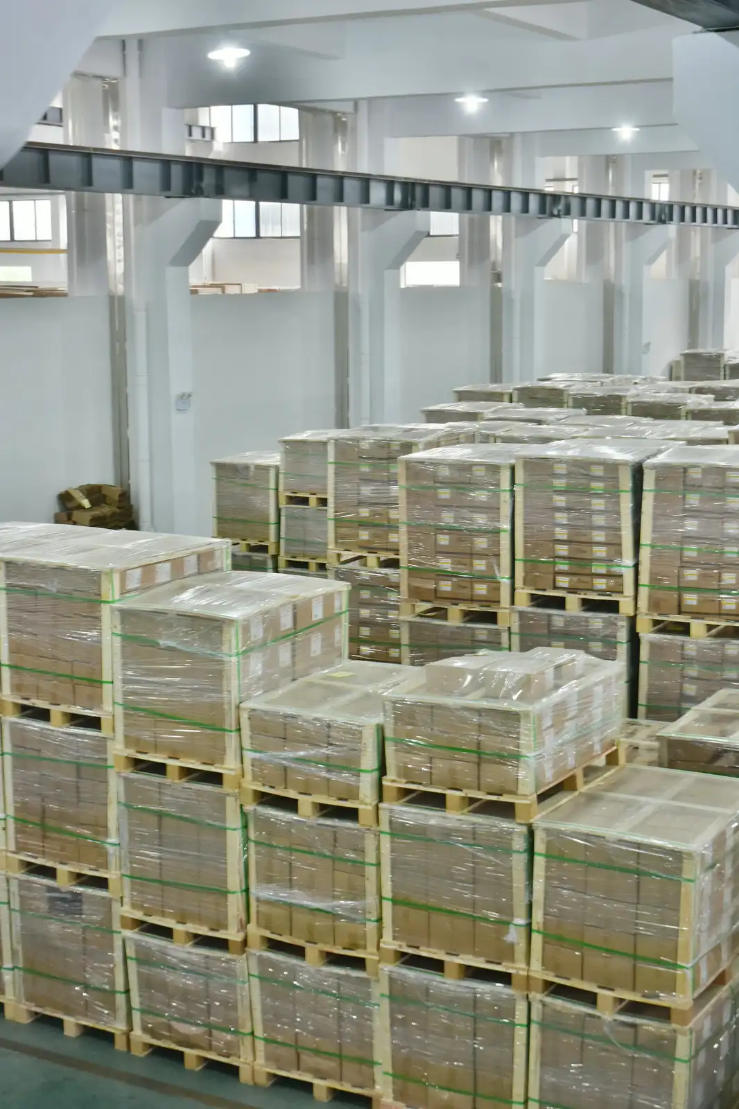 Warehouse aisle with stacked pallets of cartoned screws