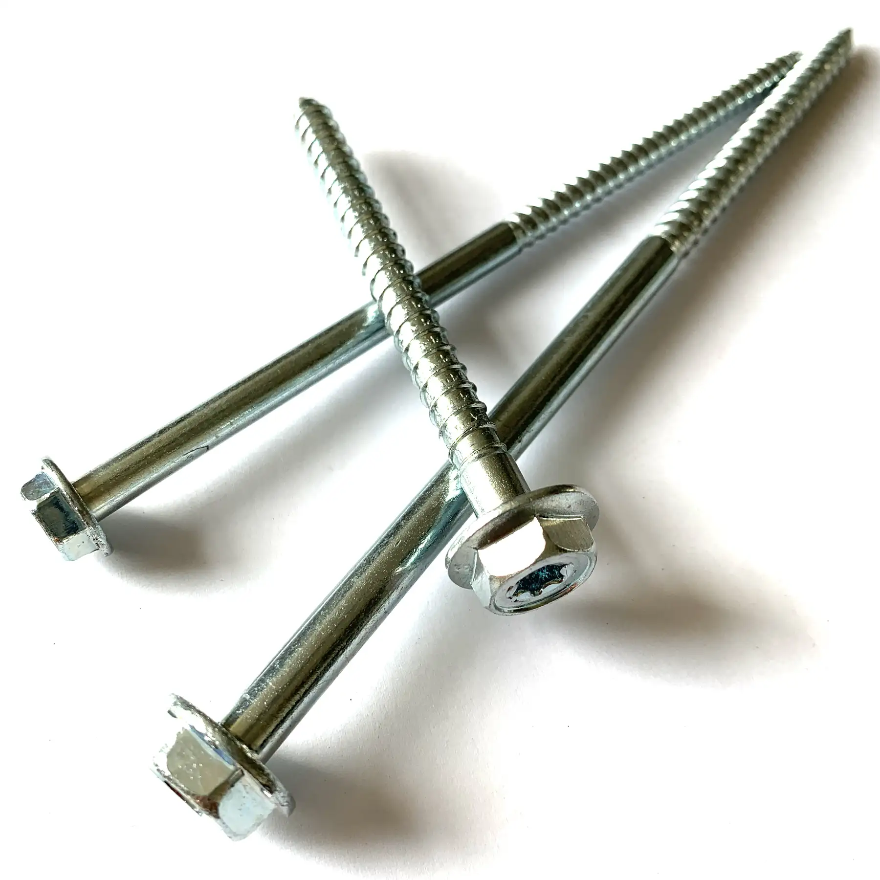 Long hexagon head wood screws with Torx recess arranged on a light background