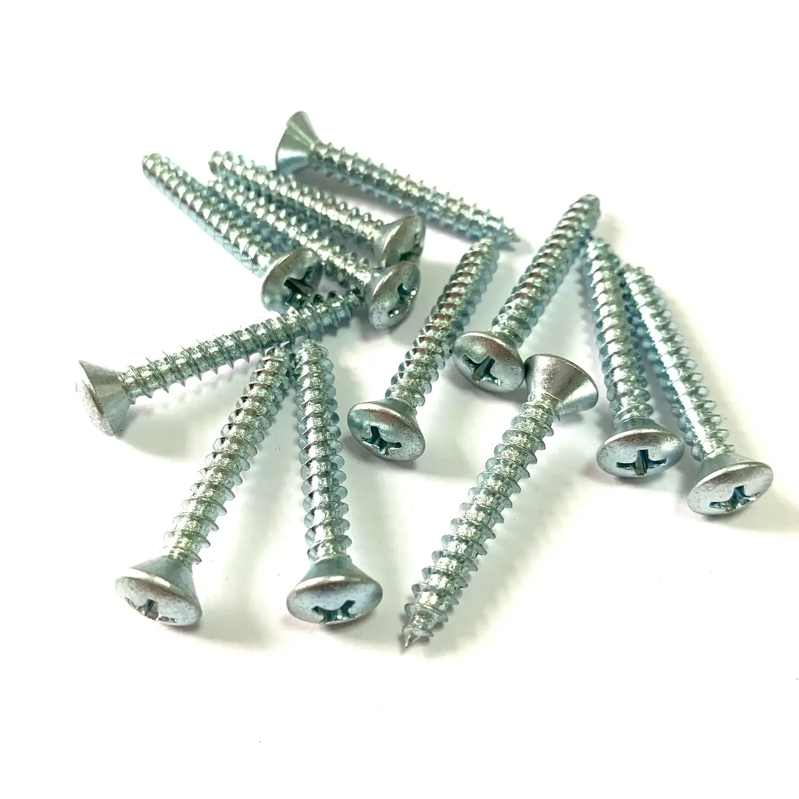 Clear zinc plated oval head Phillips window self-tapping screws in a pile
