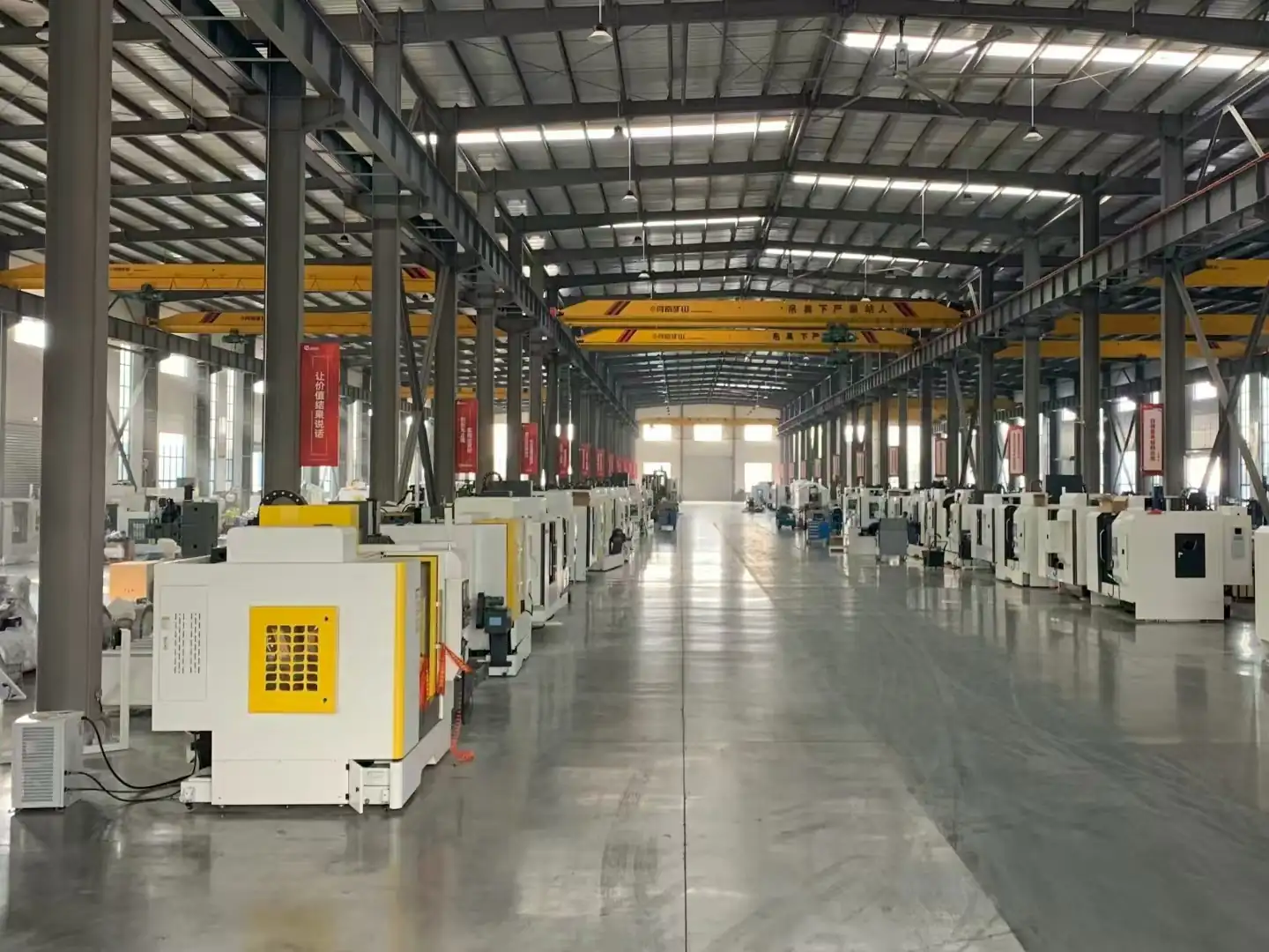 Wide view of the workshop bay with steering rack stock under the overhead crane rail
