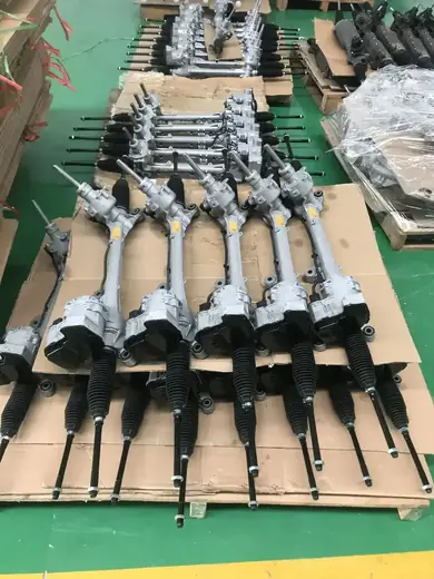 Batch of assembled steering rack units resting on a pallet in the assembly area
