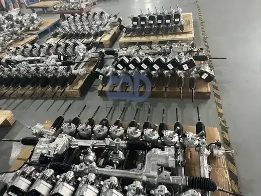 Batch of steering racks with black rubber bellows awaiting despatch