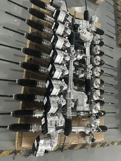 Close view of electric power steering racks laid out on a dark bench surface