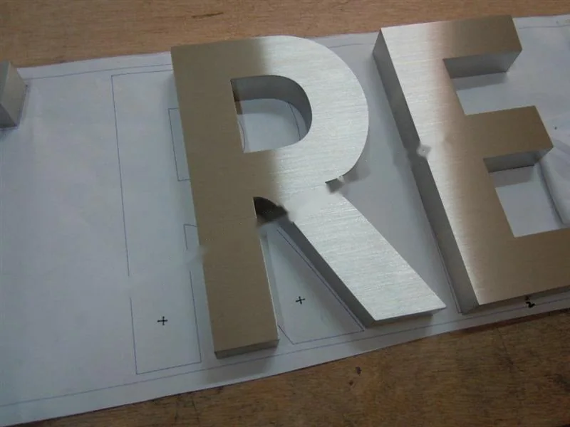 Brushed Stainless Steel relief letter sign, reference 102, photographed in the Super Enseigne workshop