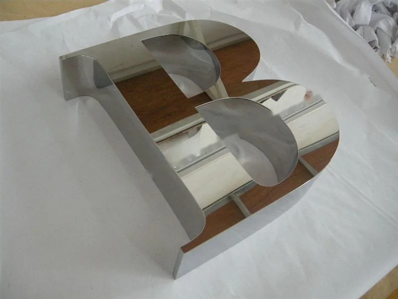Metal sign letters on the workshop bench before finishing