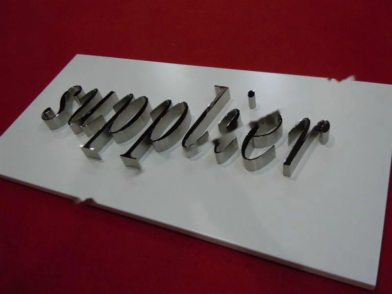 Metal sign letters on the workshop bench before finishing