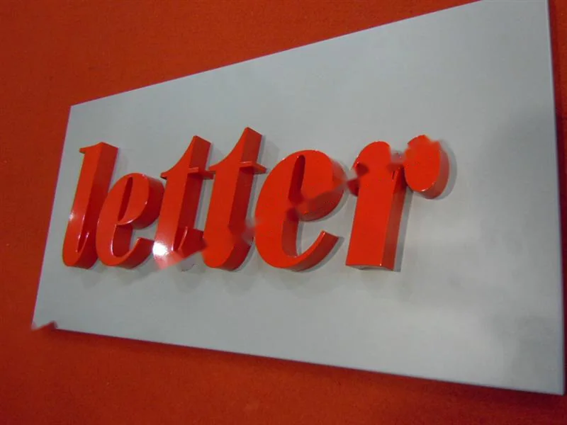 Metal sign letters on the workshop bench before finishing