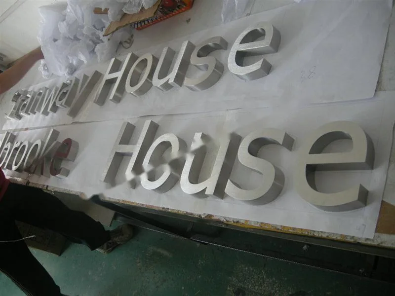 Metal sign letters on the workshop bench before finishing