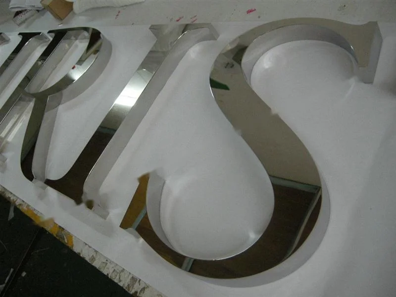 Metal sign letters on the workshop bench before finishing