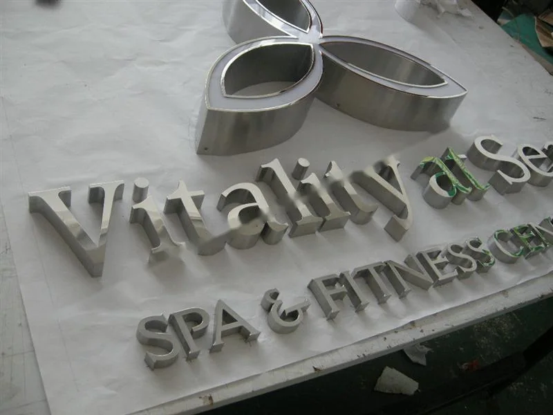 Metal sign letters on the workshop bench before finishing