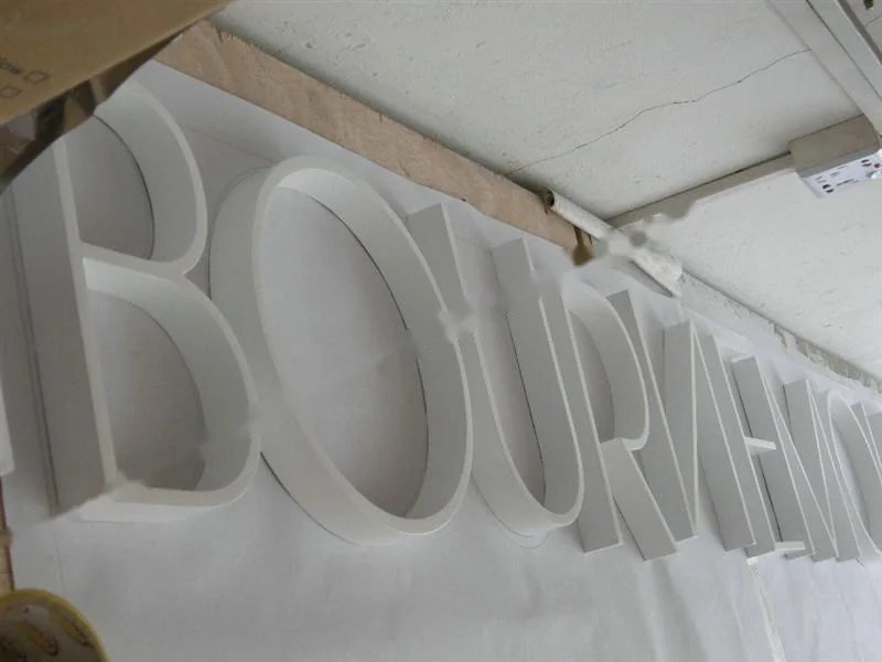 Metal sign letters on the workshop bench before finishing
