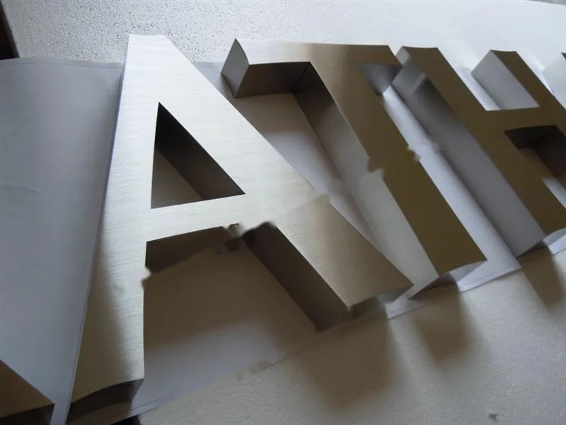 Metal sign letters on the workshop bench before finishing
