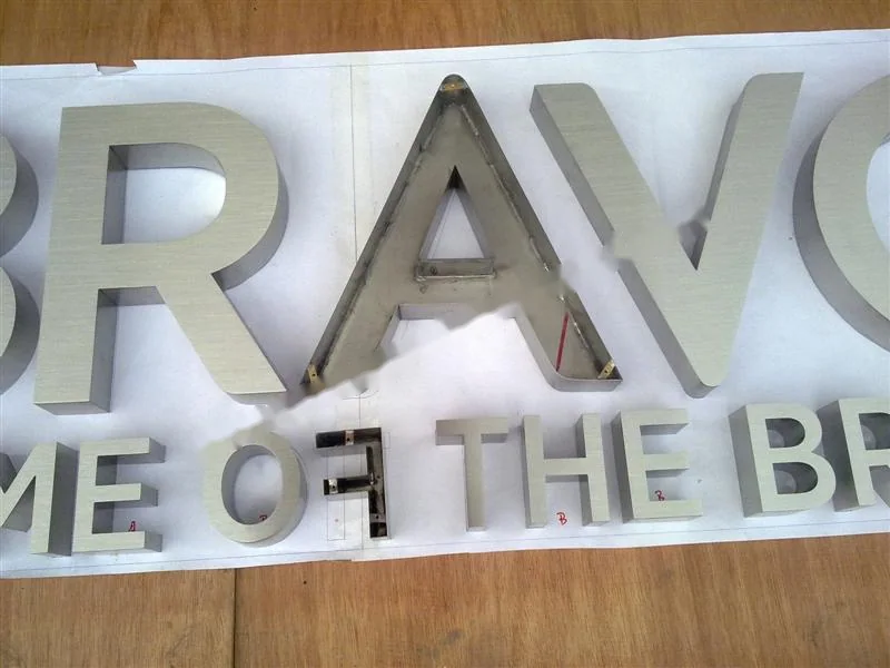 Metal sign letters on the workshop bench before finishing