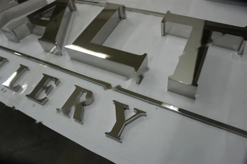 Metal sign letters on the workshop bench before finishing