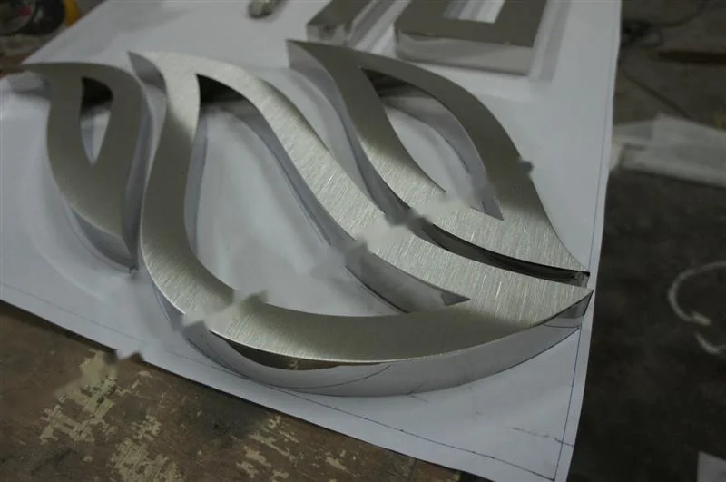 Metal sign letters on the workshop bench before finishing