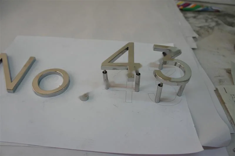 Metal sign letters on the workshop bench before finishing