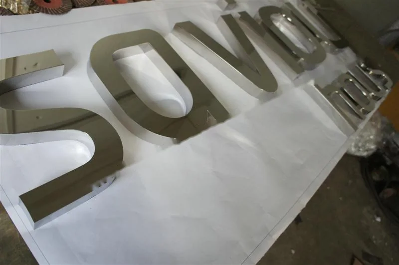 Metal sign letters on the workshop bench before finishing
