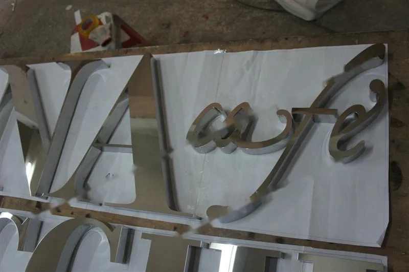 Metal sign letters on the workshop bench before finishing
