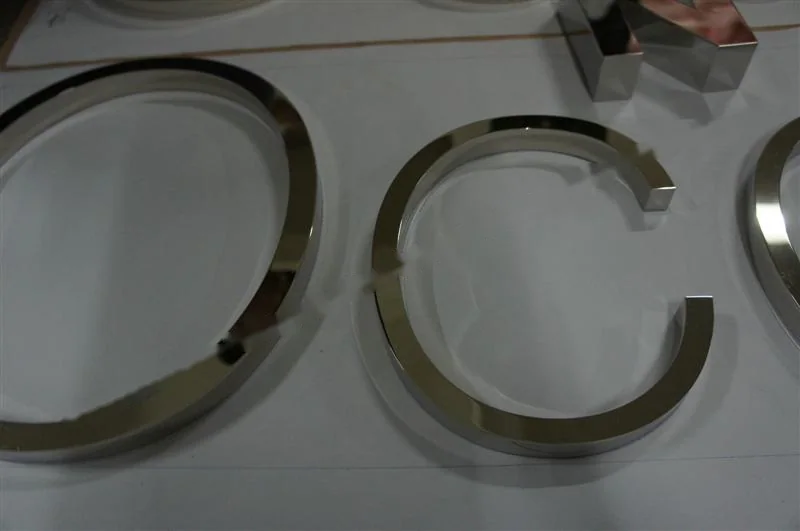 Metal sign letters on the workshop bench before finishing