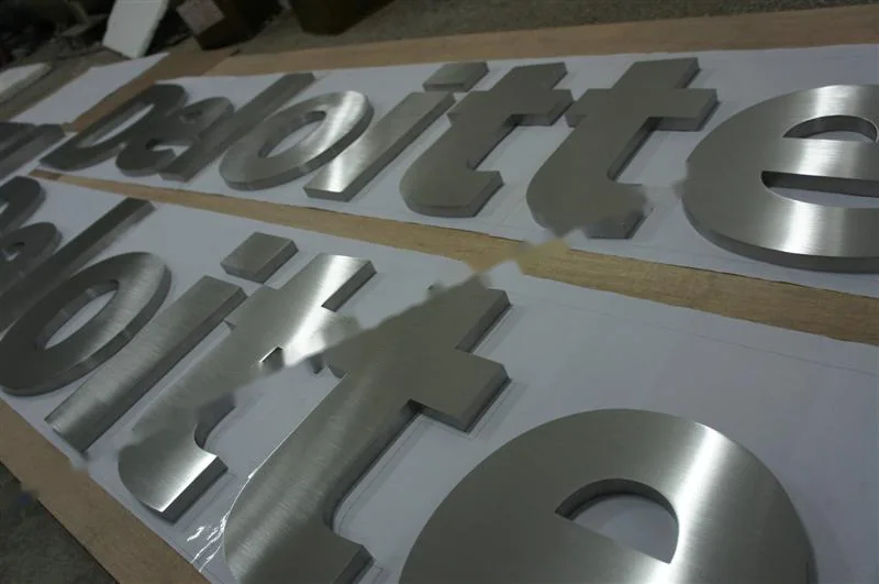 Metal sign letters on the workshop bench before finishing