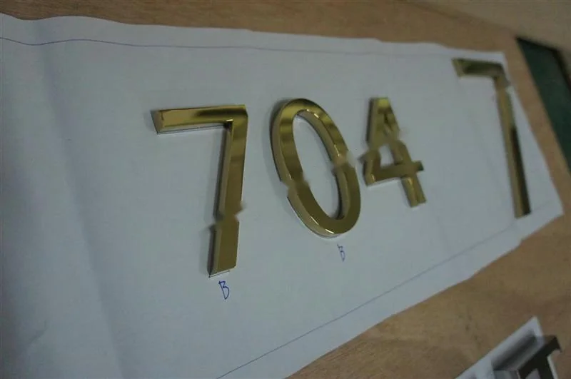 Metal sign letters on the workshop bench before finishing