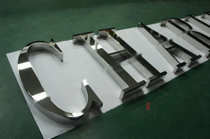 Metal sign letters on the workshop bench before finishing