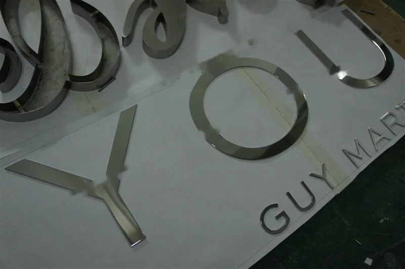 Metal sign letters on the workshop bench before finishing