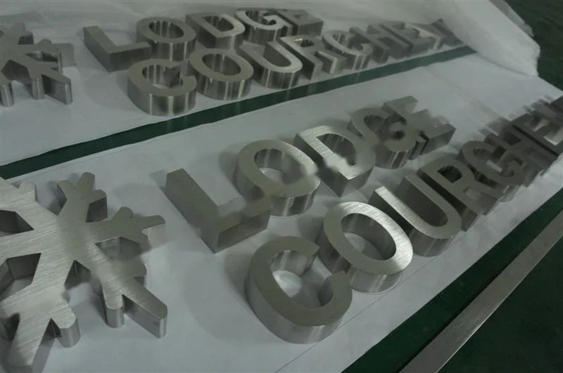 Metal sign letters on the workshop bench before finishing