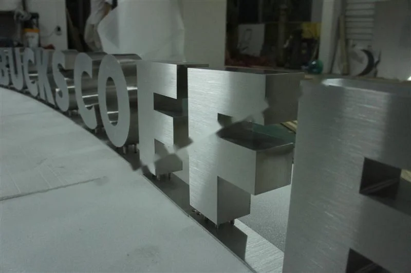 Metal sign letters on the workshop bench before finishing