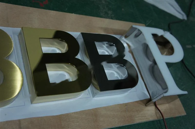 Metal sign letters on the workshop bench before finishing