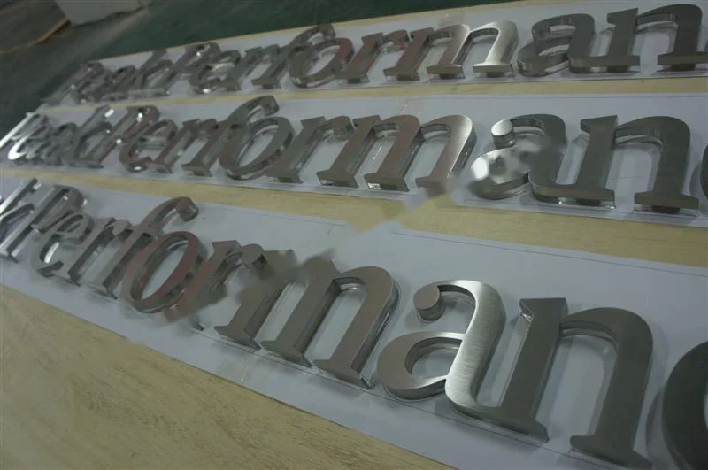 Metal sign letters on the workshop bench before finishing