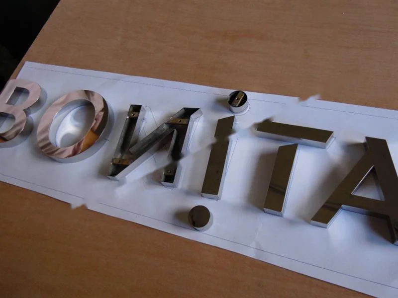 Metal sign letters on the workshop bench before finishing
